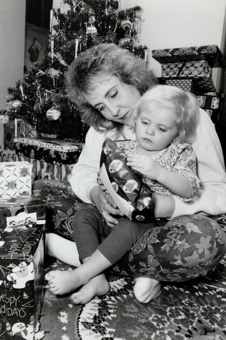 Mixed Blessings: Keri Lee Deon, mother of slain Kayla Klaudusz (inset) shows 2-year-old daughter Brittany some of the presents awaiting her under the Christmas tree