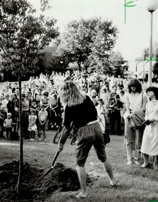 Living memorial: A friend helps to plant a lilac tree in Humewood Park - a park that slain nanny Christine Prince loved - at a memorial service for the 25-year-old Welsh woman yesterday