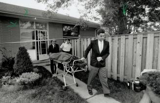 Below, officials remove one of four bodies from a Scarborough house yesterday after the incident