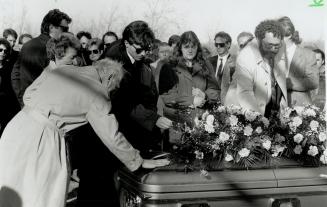 Final Farewell: Dr. Carolyn Warrick's father leans a hand on her coffin yesterday, as her fiance places a rose in her memory. The slain woman was buri(...)