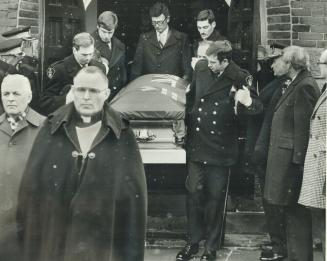 A policeman comforts a mourner at funeral of OPP Constable Duncan McAleese as the coffin is borne from Simcoe Church