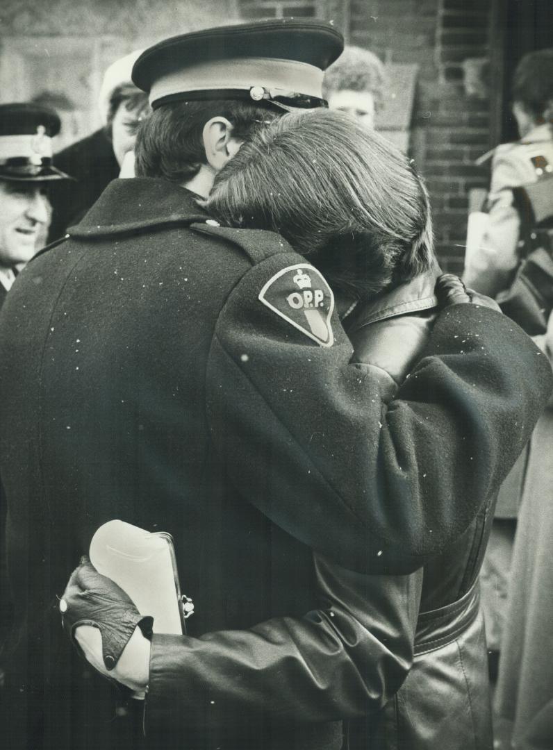 A policeman comforts a mourner at funeral of OPP Constable Duncan McAleese as the coffin is borne from Simcoe Church