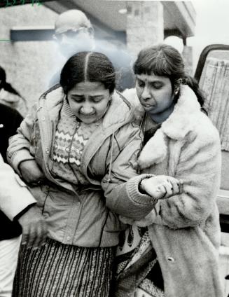 Grieving daughter: Shyamala Sathiapalan, 17, left, is comforted after yesterday's funeral for her father, Manickavasakar, 51, shot to death at an all-night gas bar in Scarborough