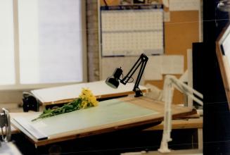 She's gone: Daisies are placed yesterday on the drafting table at Ryerson Polytechnic University where slain student Elena Tchoudakova, inset, worked