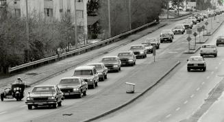 A Long procession of cars follows Volpe's body yesterday to burial in Holy Cross Cemetery in Thornhill