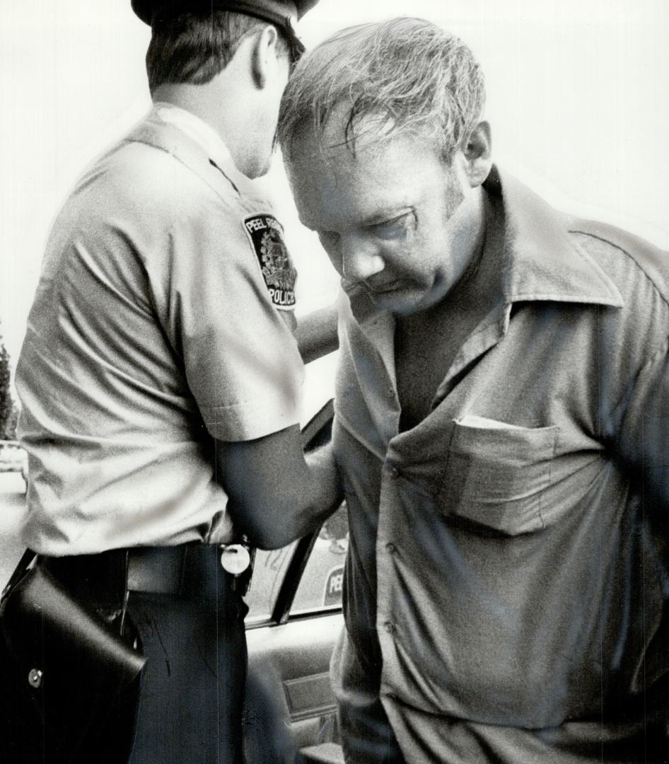 Peel Regional police constable escorts a handcuffed James Wilson Brown, 37, into Brampton Court house this morning for his court appearance. Brown is (...)