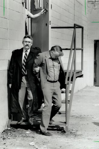 Court appearance: Sergeant David Mattison, right, accused of murdering his wife, is escorted out of Scarborough court in handcuffs today