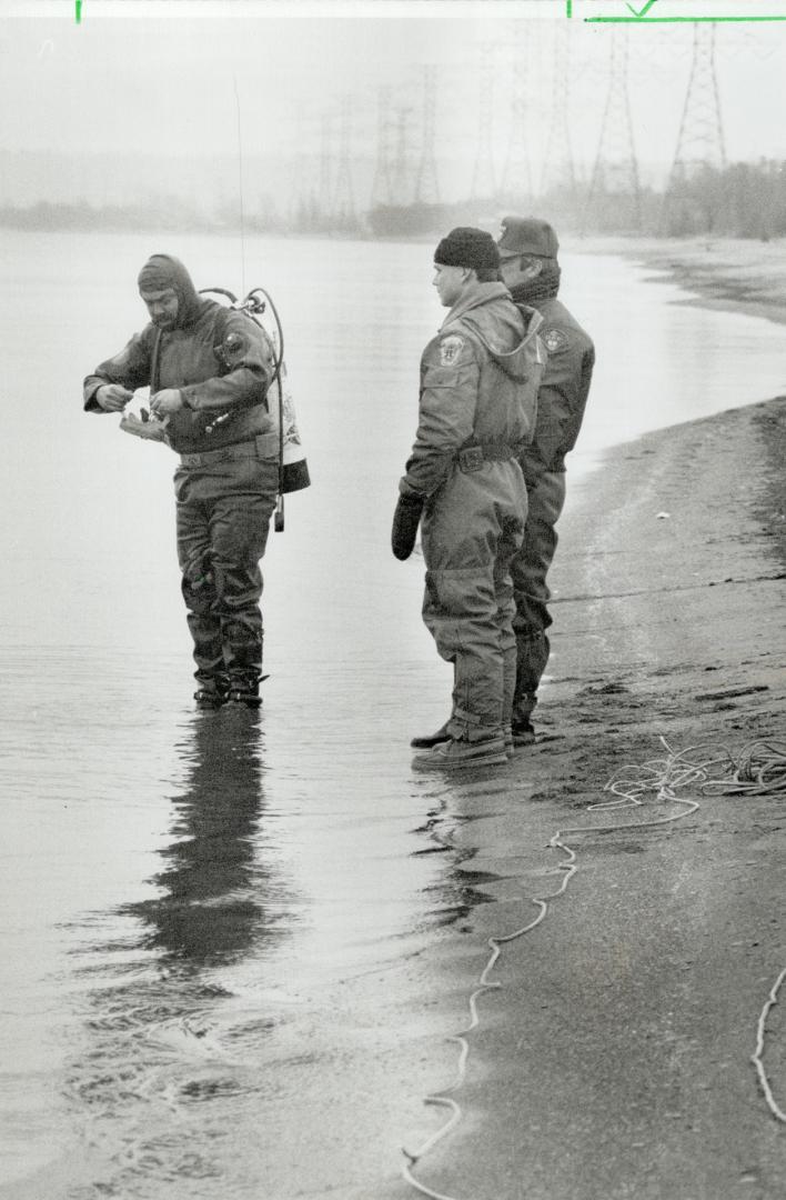 Grim work: A police diver prepares to search a section of Lake Ontario yesterday off Hamilton for more body parts after a severed limb was found