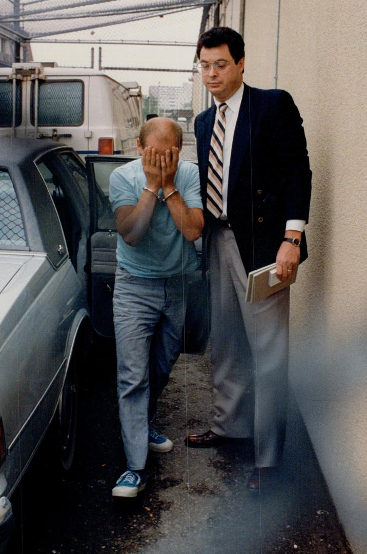 Murder suspect: Joseph Robert Fredericks covers his face outside court yesterday