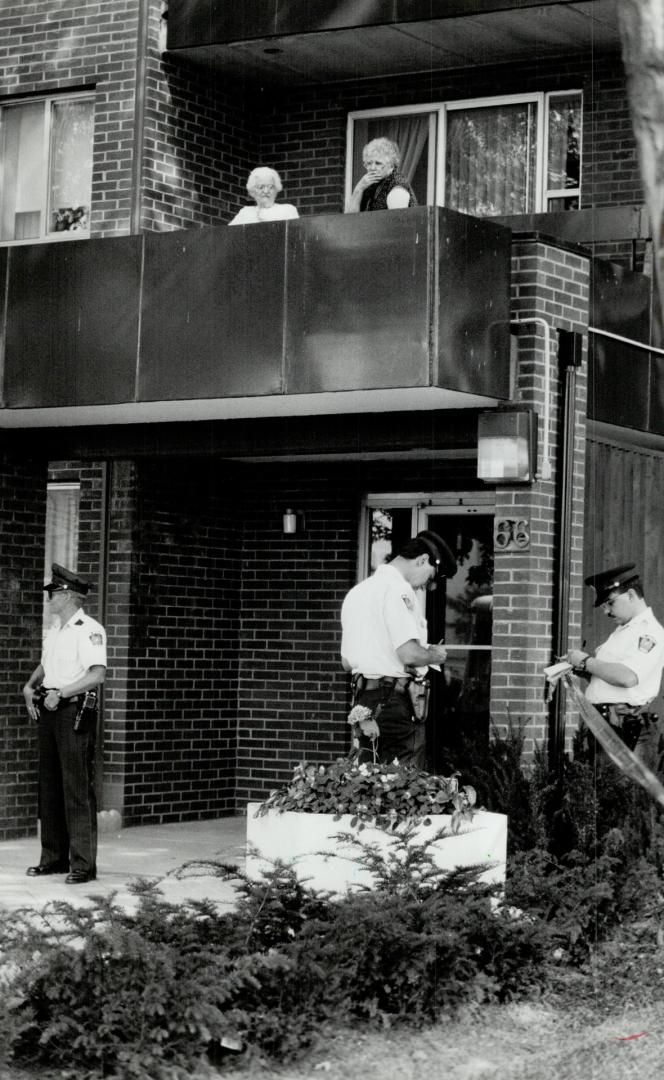 Crime scene: Residents look on yesterday as Peel Region police investigate the killing of a woman in a seniors' apartment complex in Mississauga