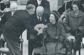 Usually somebody's daughter presents flowers to the Queen but this time premier of P.E.I. Walter Shaw hands a bouquet to Her Majesty. It was a busy day for Royal couple who dedicated $5;600;000 Fathers of Confederation Memorial buildings which commemorate Canada's birth. Visit is culmination of summer-long ceremonies which drew record number of tourists to the island province.