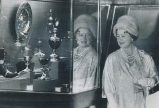 A moment for Royal Reflection, The Queen Mother's image is mirrored on a display case at the Royal Ontario Museum today while she studies part of the (...)