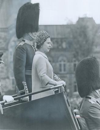 Bearskin Hatted officer towers over the Queen yesterday at color ceremony at Parliament Hill, in Ottawa