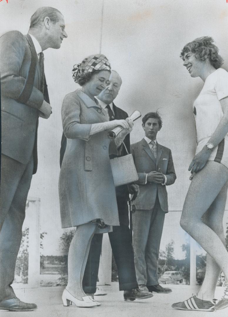 Baton to be used to officially open Commonwealth Games in Edinburgh is presented to runner Abigail Hoffman, of Toronto, by Queen Elizabeth. Watching a(...)