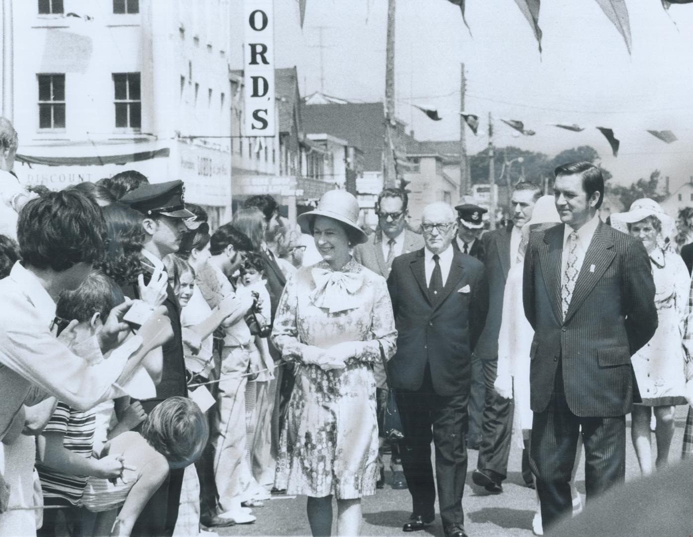 The Queen, accompanied by Prince Edward Island Premier Alex Campbell, right, walked down main street in Charlottetown yesterday to greet the thousands(...)