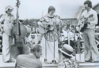 Acadian musicians entertain the Queen and Prince Philip with folksongs of the area during their visit to a reconstructed Acadian village at Mount Carmel