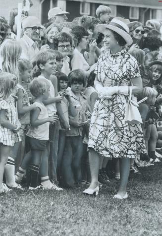 The Queen smiles at children and adults while she tours the reconstructed Acadian village at Mount Carmel, P