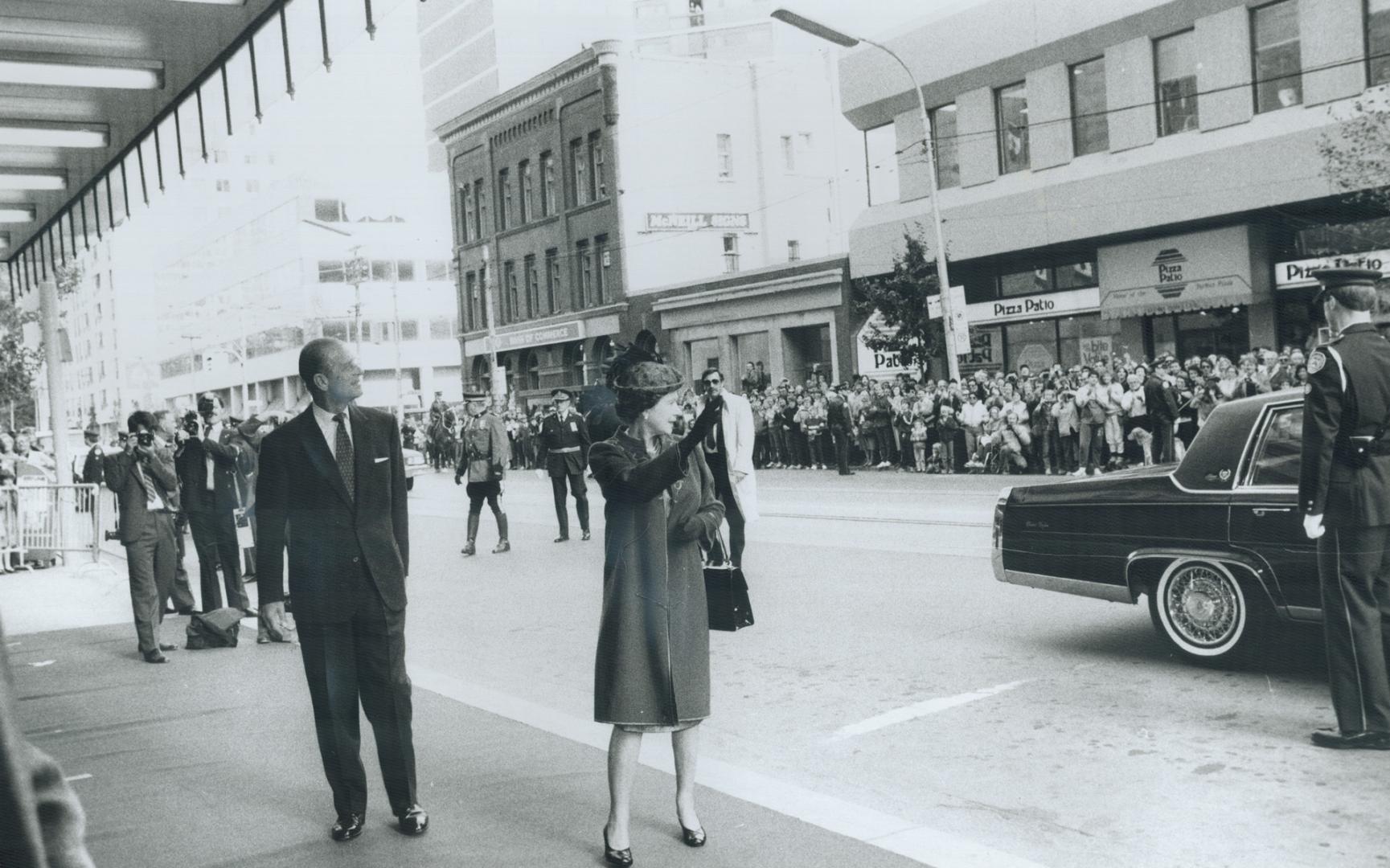 Royals acknowledge fans: The Queen waves to admiring crowds as she and Prince Philip prepare to enter Maple Leaf Gardens for a service of thanksgiving featuring leaders from several different faiths