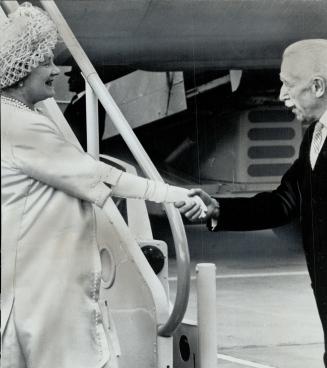 Courtly Governor General Vanier appears, takes hand lightly clasps it gently