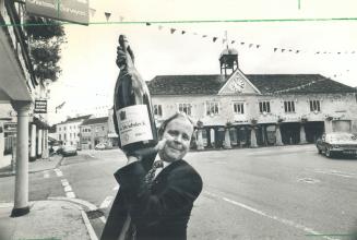 Bubbling over: Insurance broker Jeremy Kahagan holds up a bottle of champagne that's likely to provide many a toast to the royal couple