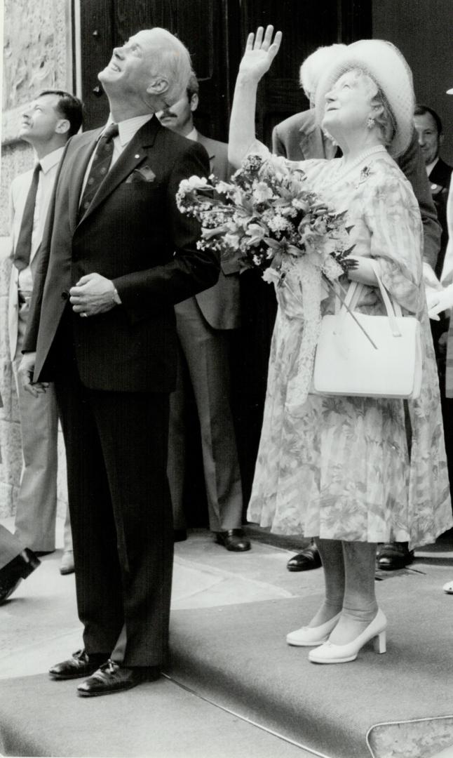 The Queen mother is escorted to here car by Hartland MacDougall national deputy chairman of the Duke of Edinburgh's awards in Canada