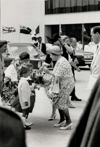 Breezy Farewell: Wind whips bystanders at Pearson Airport yesterday as the Queen Mum accepts a bouquet from admirers before embarking on her return flight of Britain