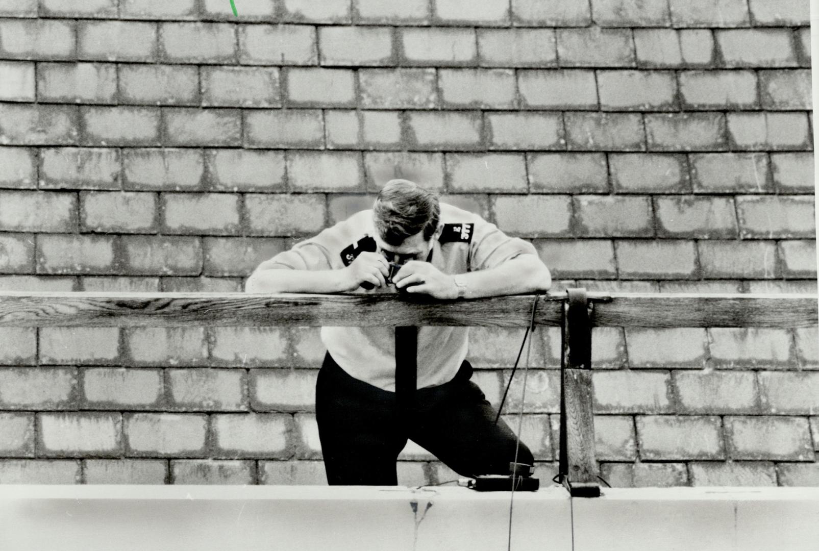 Bird's eye view: A London policeman looks down through binoculars for any sign of trouble in the crowds