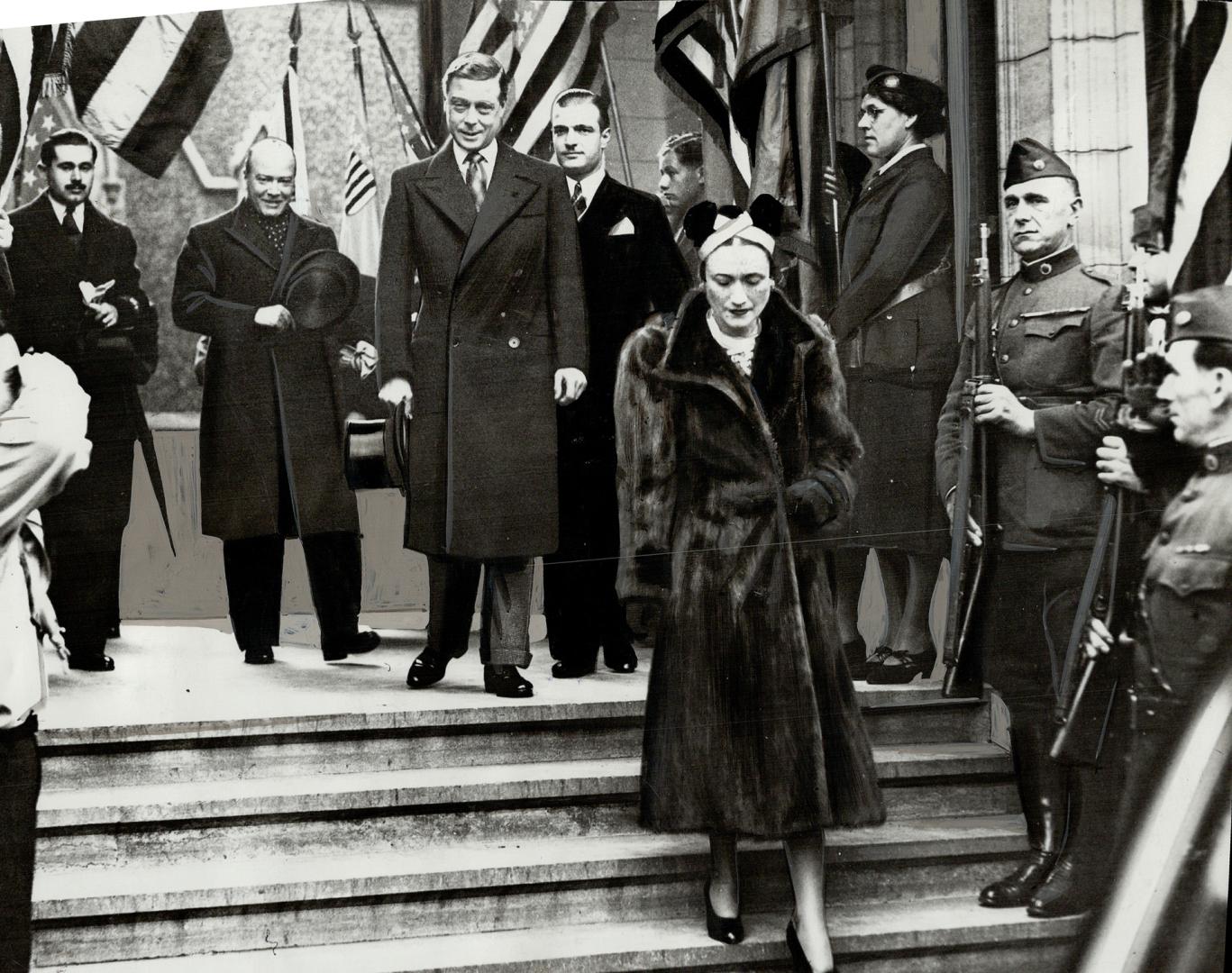 War Veterans give salute, The Duchess of Windsor looks grave, while the Duke smiles, as they leave the American church in Paris after attending Thanksgiving Day services