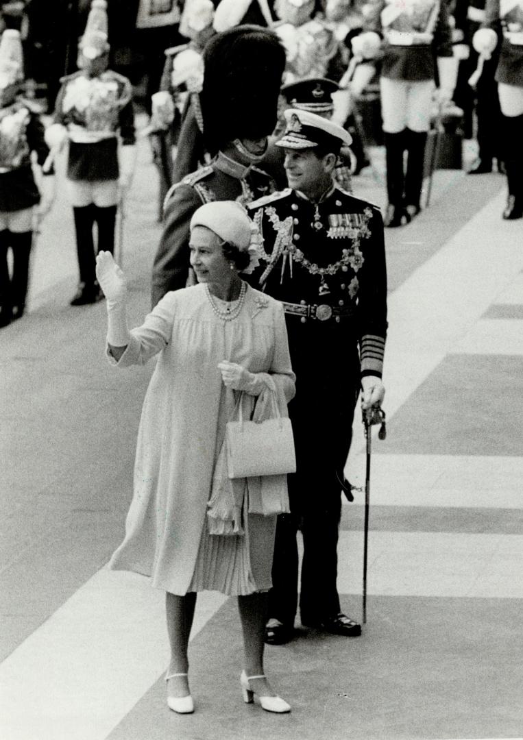 Queen Elizabeth II turns and waves to cheering crowds outside St Paul's Cathedral on her arrival with Prince Philip