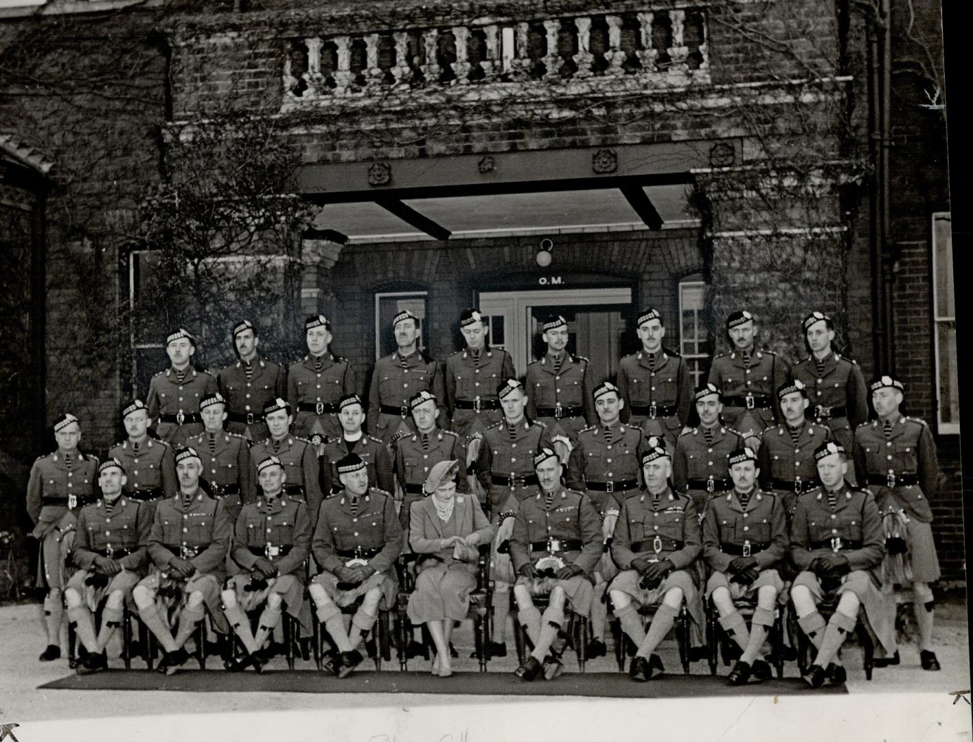 Queen Elizabeth, colonel-in-chief of the Toronto Scottish, after reviewing her regiment, had lunch and posed with the officers at Tournay Barracks and(...)