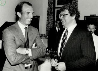 Captain Mark Phillips, left, gets an enthusiastic greeting from Brent Bertrant, vice-president of the Windsor Arms Hotel. Phillips helped raise support for CARD