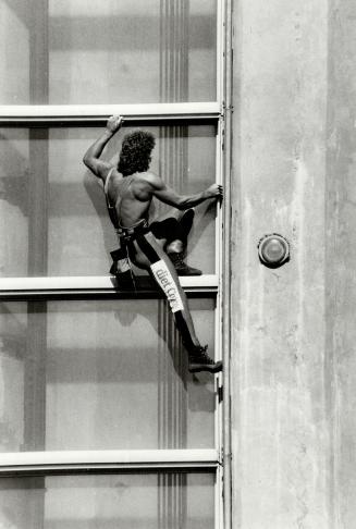 Showing the skills and iron nerve that make him the ''human fly,'' Dan Goodwin grips the aluminum sills that are his only support as he climbs the CN Tower today