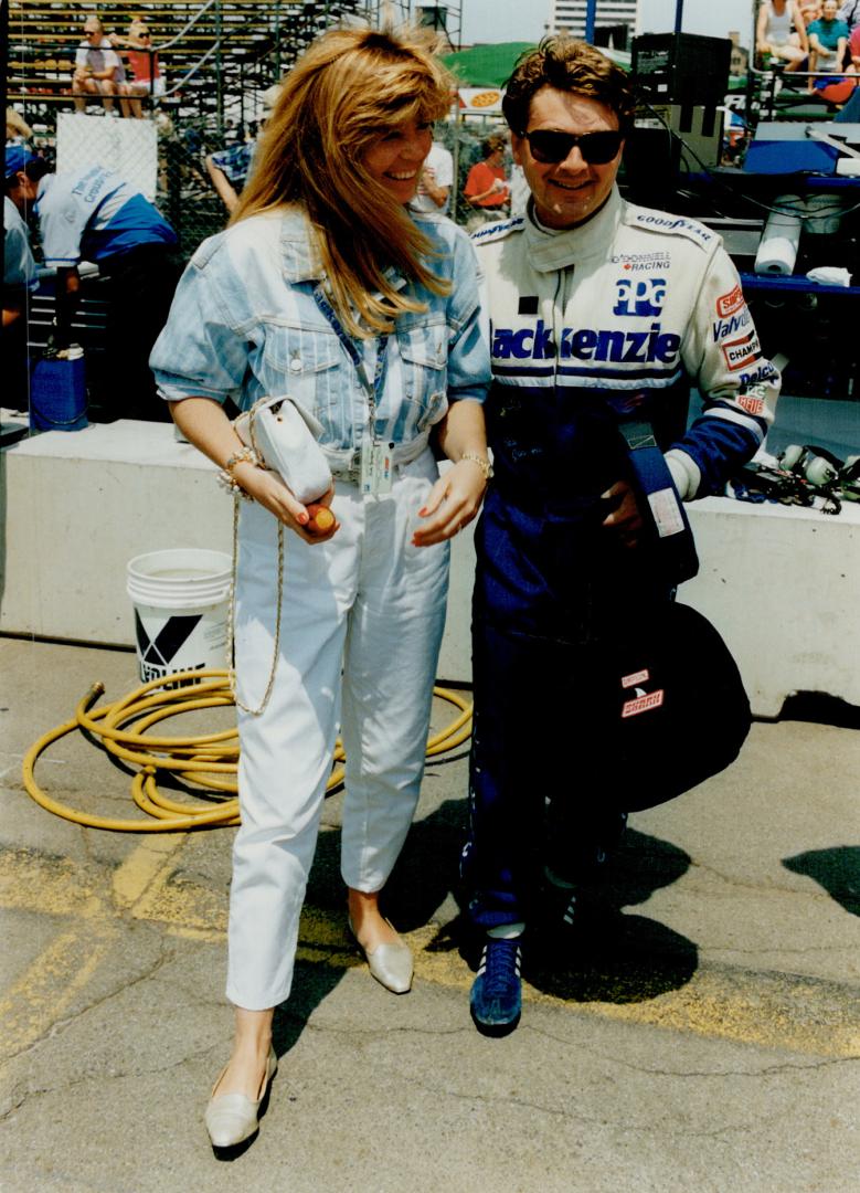 Former F1 titlists Emerson Fittipaldi and Mario Andretti (top) pass the time on Detroit's pit row