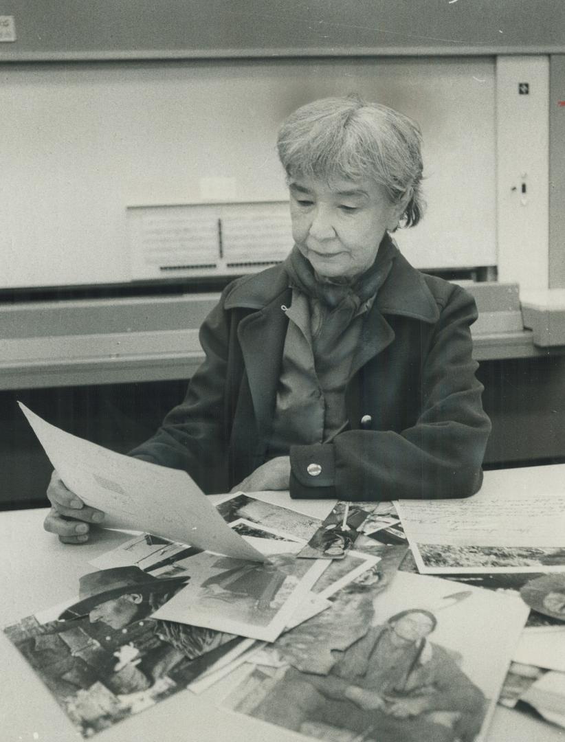 Anahareo, Mrs. Grey Owl, looks at husband's pictures: She has written a book on her years with controversial Grey Owl