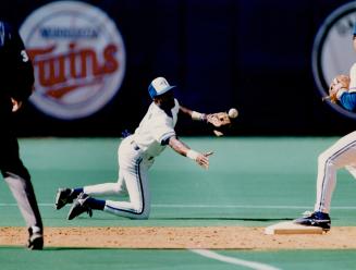 Call it two: Alfredo Griffin snares a hot smash up the middle and shuffles the ball to Roberto Alomar, who avoids Ranger Dan Peltier to turn a double play yesterday