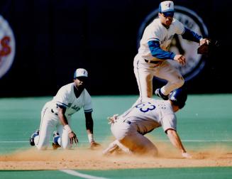 Call it two: Alfredo Griffin snares a hot smash up the middle and shuffles the ball to Roberto Alomar, who avoids Ranger Dan Peltier to turn a double play yesterday