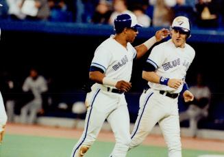 Grand Gesture: Kelly Gruber has taken his share of knocks this year, but here Candy Maldonado has a chance to congratulate him for his grand slam shot in the seventh inning last night