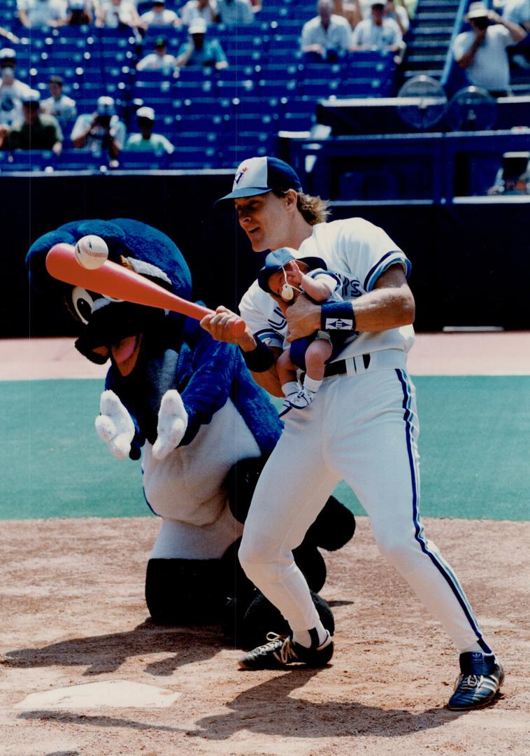 Handy Man: Kelly Gruber holds infant son Kody in one hand and smacks a single with the other in Blue Jays' annual father-kids game yesterday