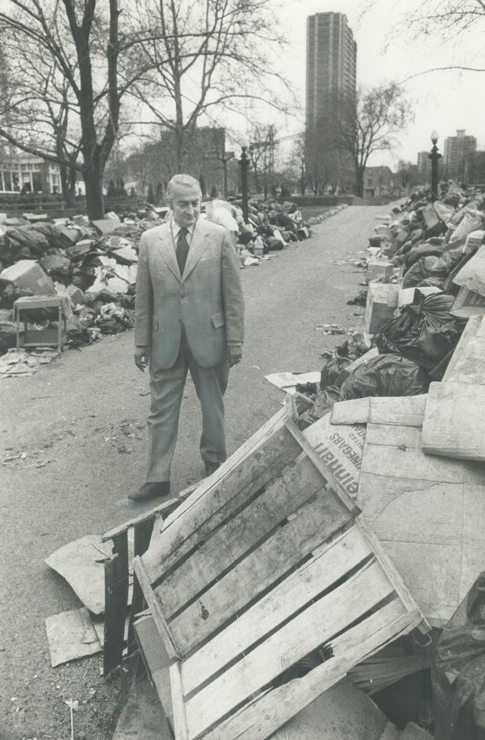 Labor Minister Fern Guindon, who proposed the compromise that ended the four-week strike by Metro and Toronto civic workers, walks between rows of gar(...)