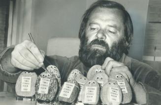 Guilded rocks: Oshawa Times reporter Arnie Hakala looks over the ''guilded rocks'' that newspaper Guild strikers at the Times are selling to augment their strike pay