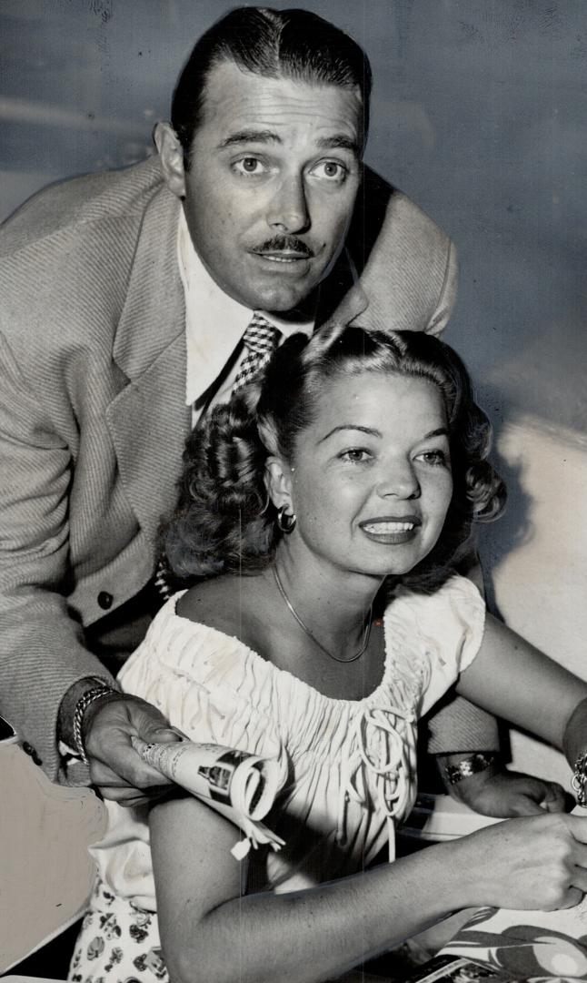 Beaten by a nose, Jon Hall and his songstress wife, Frances Langford, watch as the finish sign says their choice came second in a Santa Anita race