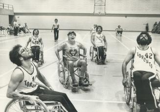 Celebrity team's Don Harron (centre) keeps eye on action in game with Thunderbirds