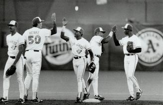 Slap-happy guys: Tom Henke, left, Manuel Lee, Candy Maldonado and Devon White swap high-fives after the Jays topped Orioles 4-2 to gain split of series