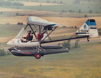 Man giving thumbs up in open air cockpit of small plane