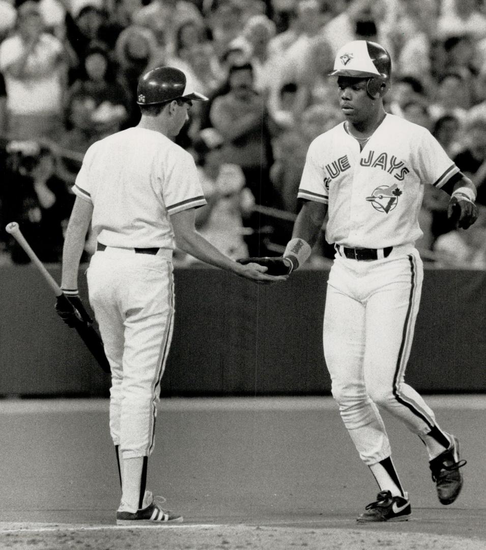 Welcome home: Rookie Glenallen Hill gets five from the Blue Jay batboy after clubbing a grand slam home run in the fourth inning last night against the Twins