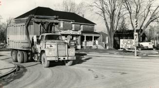 A garbage truck rolls through Maple