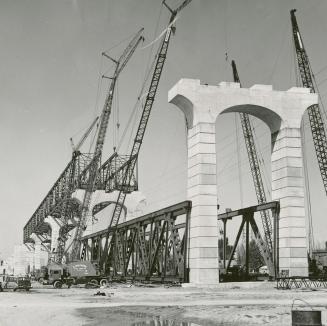 Giant cranes are ready to lift a section of the road on to the concrete columns