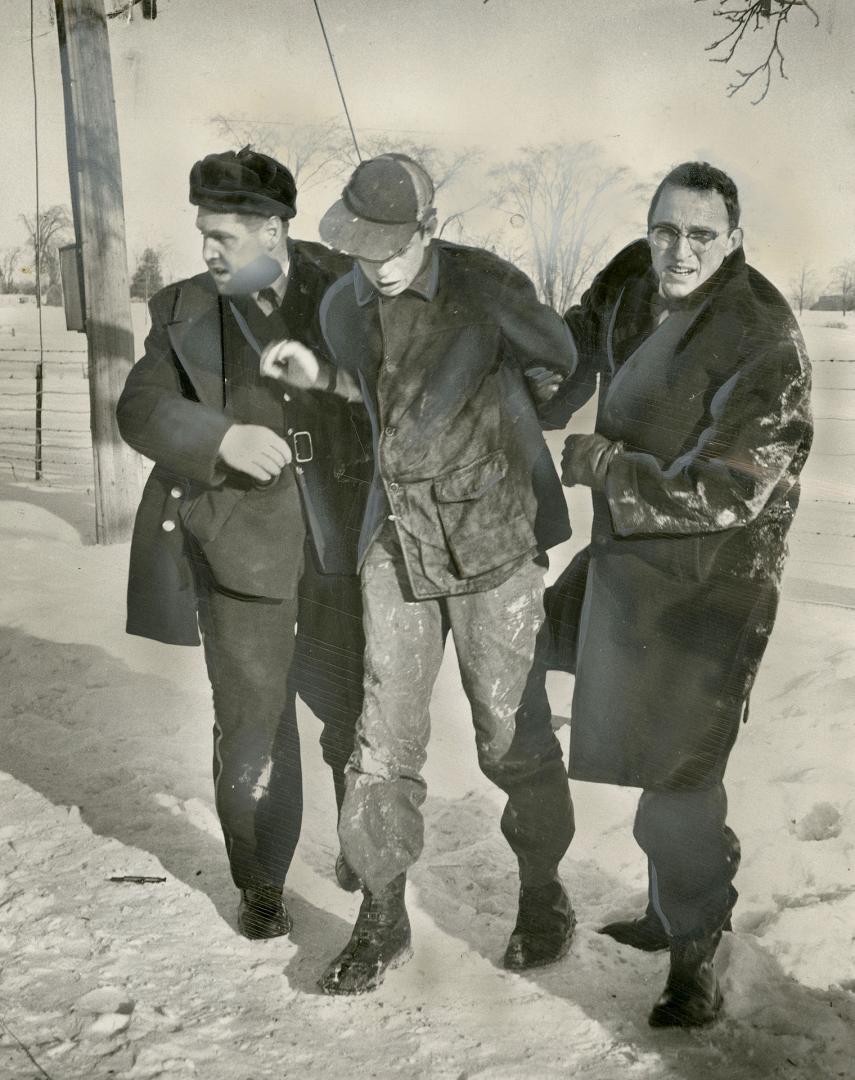 Pinned: OPP constable and reporter Russell Cooper hold youthès arms tightly behind his back after they disarmed him of gun and ball bat in struggle on ground