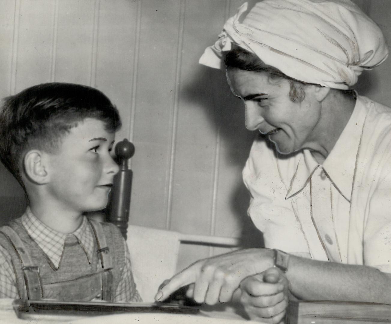 Mrs. Rudolph Hess, wife of the one-time No. 2 Nazi who is awaiting trial at Nuremberg, helps her seven-year-old son Wolf with his lessons in their apartment in Bad Obersdorf