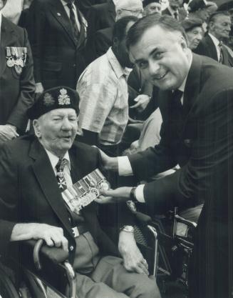 Medals of honor: Governor-General Ray Hnatyshyn admires the war medals of Dieppe and World War I veteran John Housser, 78, during a wreath-laying ceremony today at the Cenotaph at Old City Hall